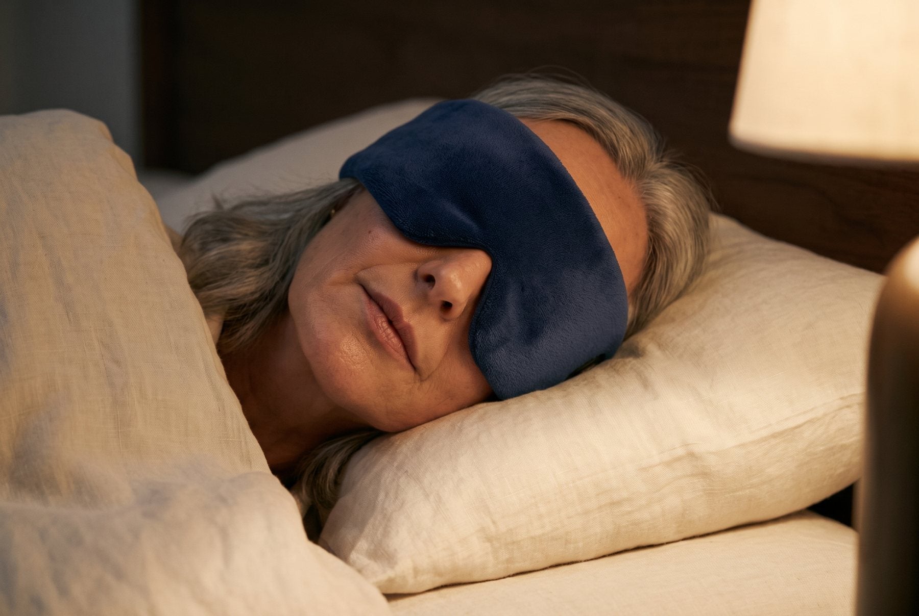 Asleep on her side still wearing the cordless heated eye mask