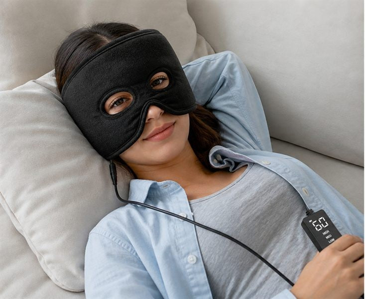 A woman lying back on a sofa with the mask on, holding the controller